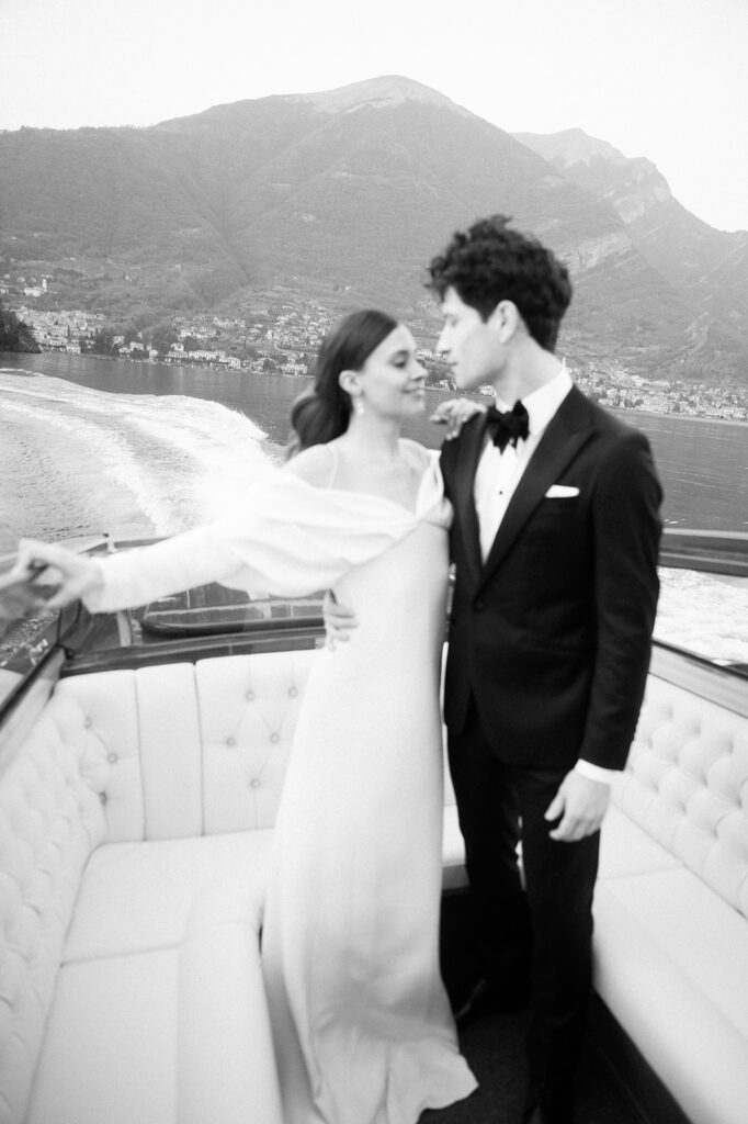 Couple holding each other on a classic boat during their Lake Garda elopement