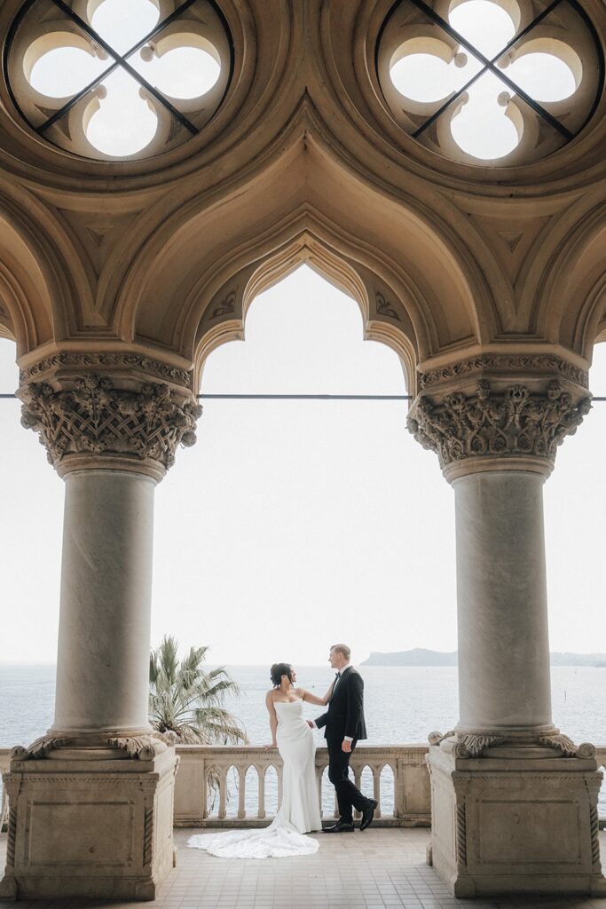 Bride and groom standing under the arches of Isola del Garda during their elopement wedding photographer