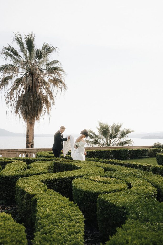 Couple walking through manicured gardens during their Isola del Garda wedding photographer