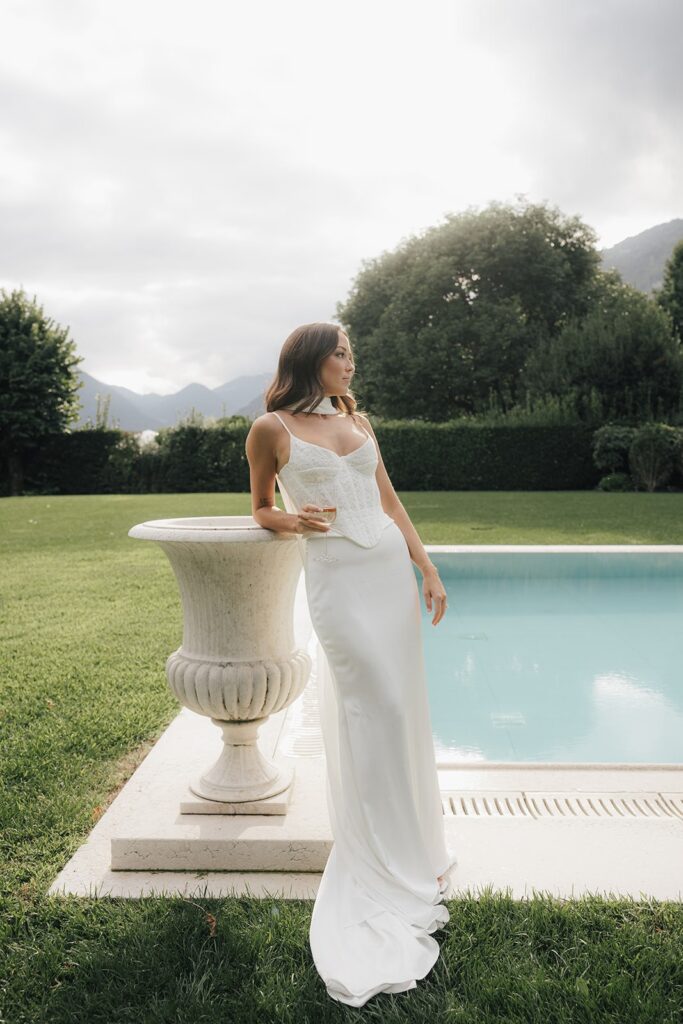 Bride standing by poolside at a luxury Italian villa during Lake Garda elopement wedding photographer