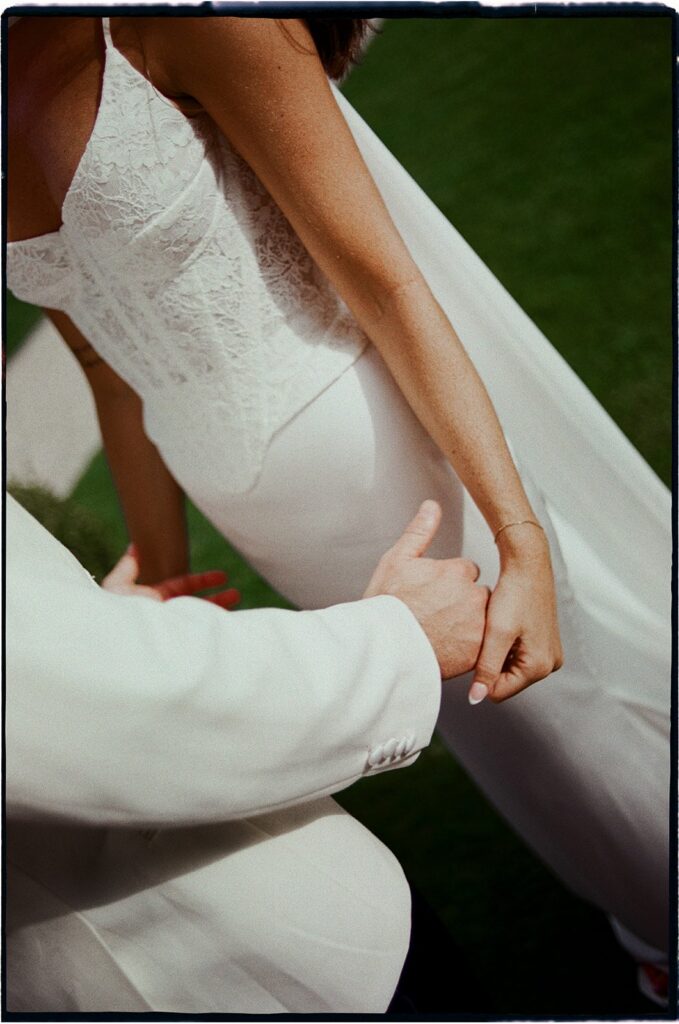 Bride and groom holding hands during their Lake Garda wedding ceremony captured on film