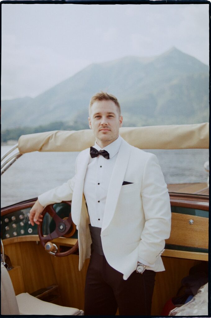 on 35 mm film Editorial groom portrait on a vintage boat during a Lake Garda elopement
