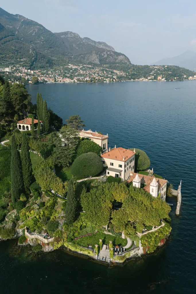 Drone photo of Villa del Balbianello on Lake Como, iconic wedding venue with gardens and mountain views.