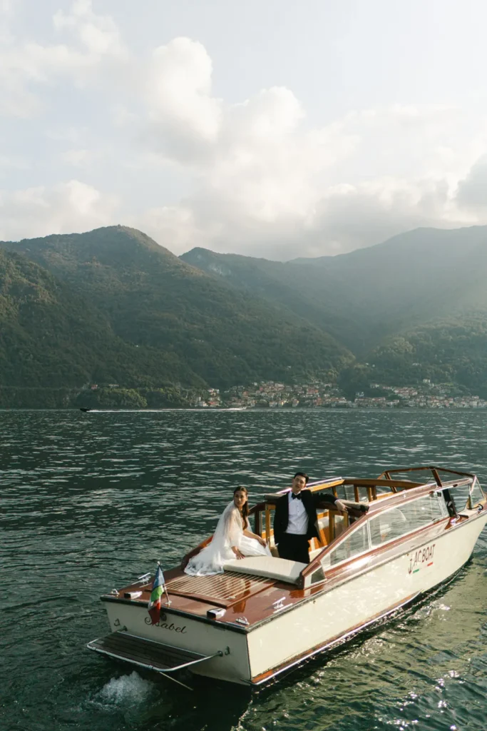 Classic wooden boat on Lake Como with the couple, cinematic elopement photos near Villa del Balbianello
