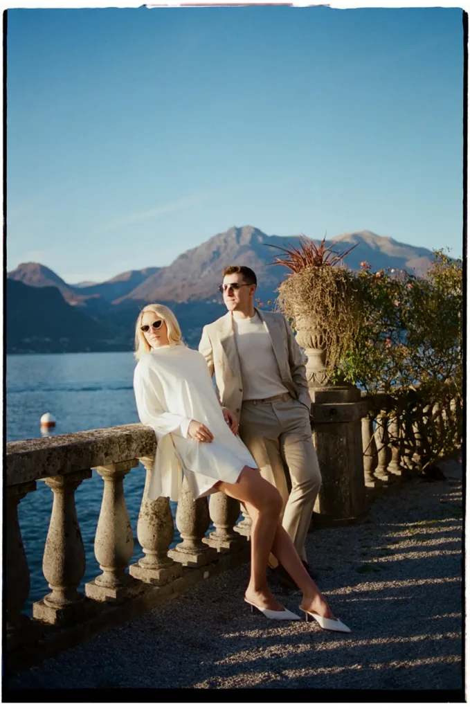 Elegant couple posing by the lakeside balustrade at Grand Hotel Villa Serbelloni Bellagio, Lake Como in warm afternoon light